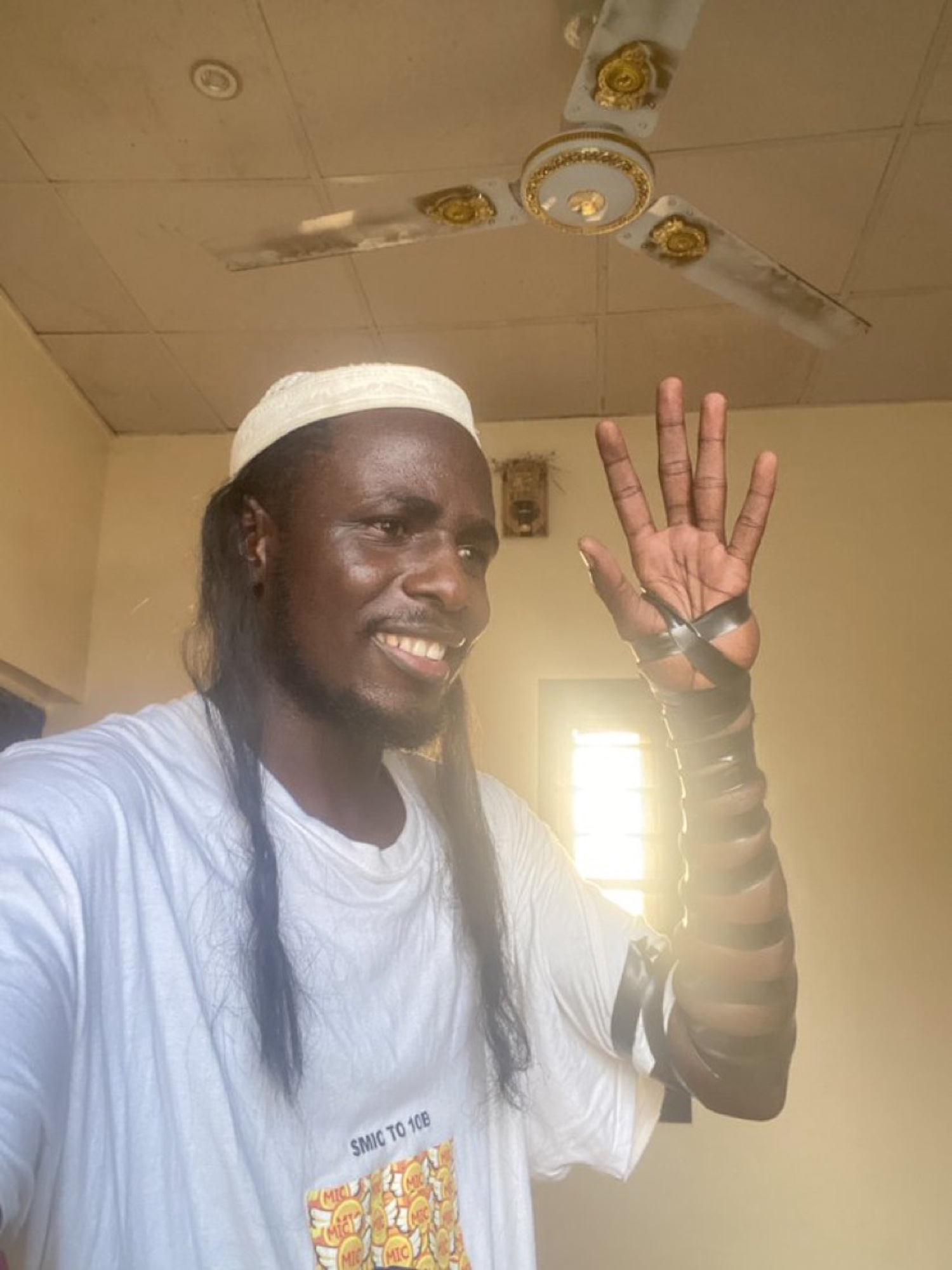 Bitcoin Obama, the Nigerian crypto shiller, waving in a white cap and SMIC to 10B t-shirt